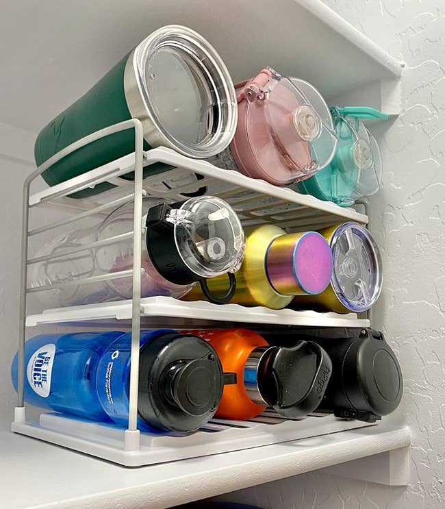 The inside of a reviewer's cabinet using the 3 shelved water bottle organizer which fits 9 reusable water bottles