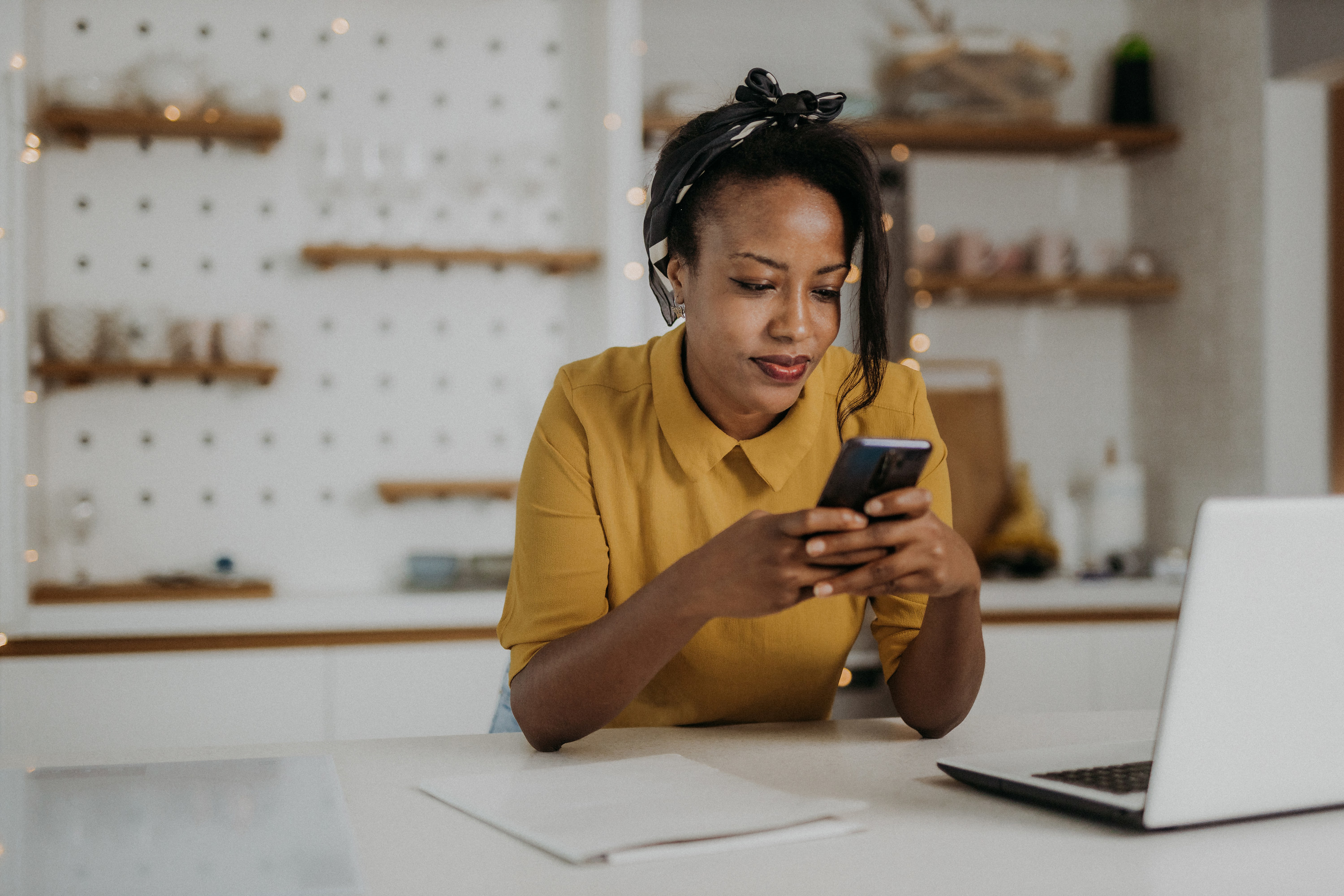 Woman in a workshop looking at her phone