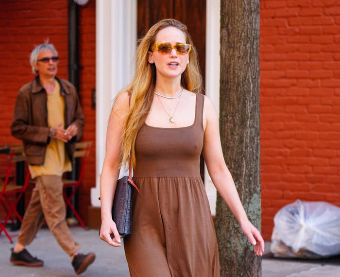 Jennifer walking outside in a casual dress and sunglasses