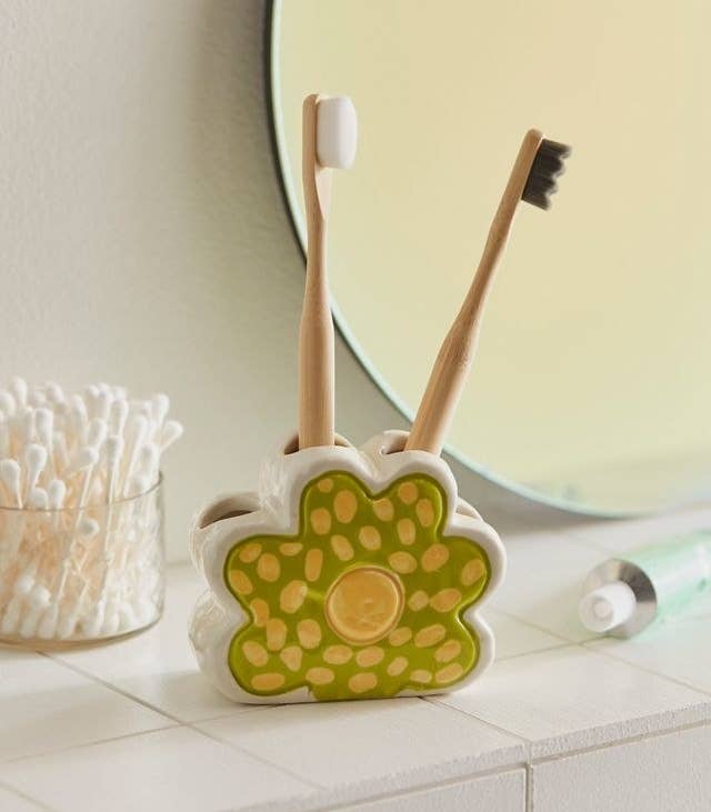 a flower shaped toothbrush holder with four slots