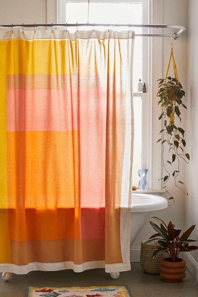 a warm-coloured shower curtain in a stylish bathroom