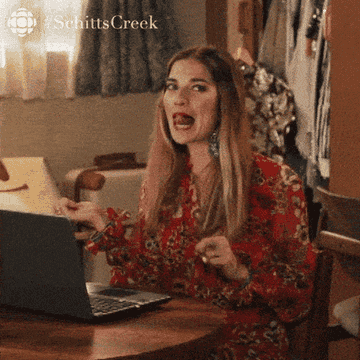 A gif of Alexis Rose from Schitt&#x27;s Creek repeatedly whipping her hair behind her shoulders excitedly