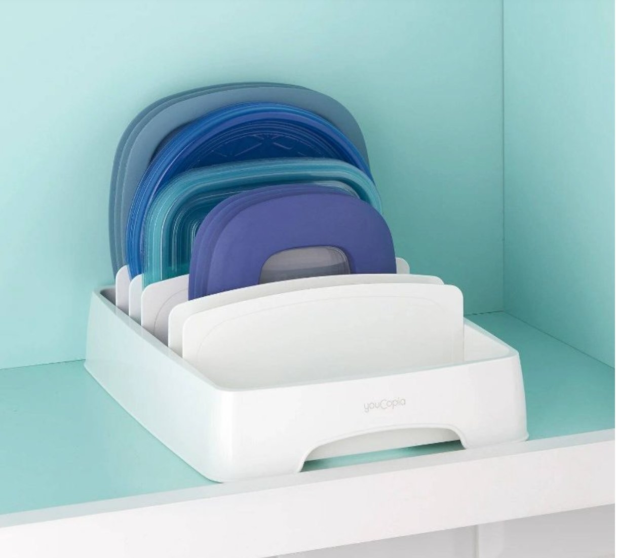 the white organizer with blue lids in a blue cabinet