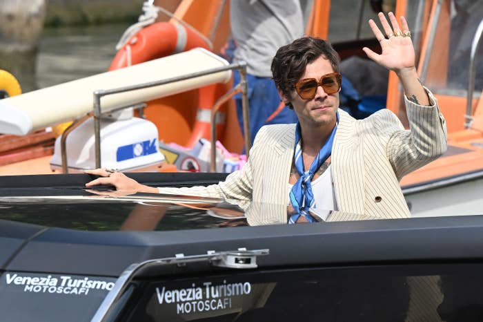 Harry waves from a boat