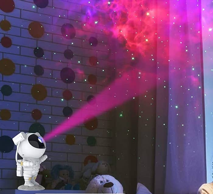 the lamp on a table projecting a nebula in a room