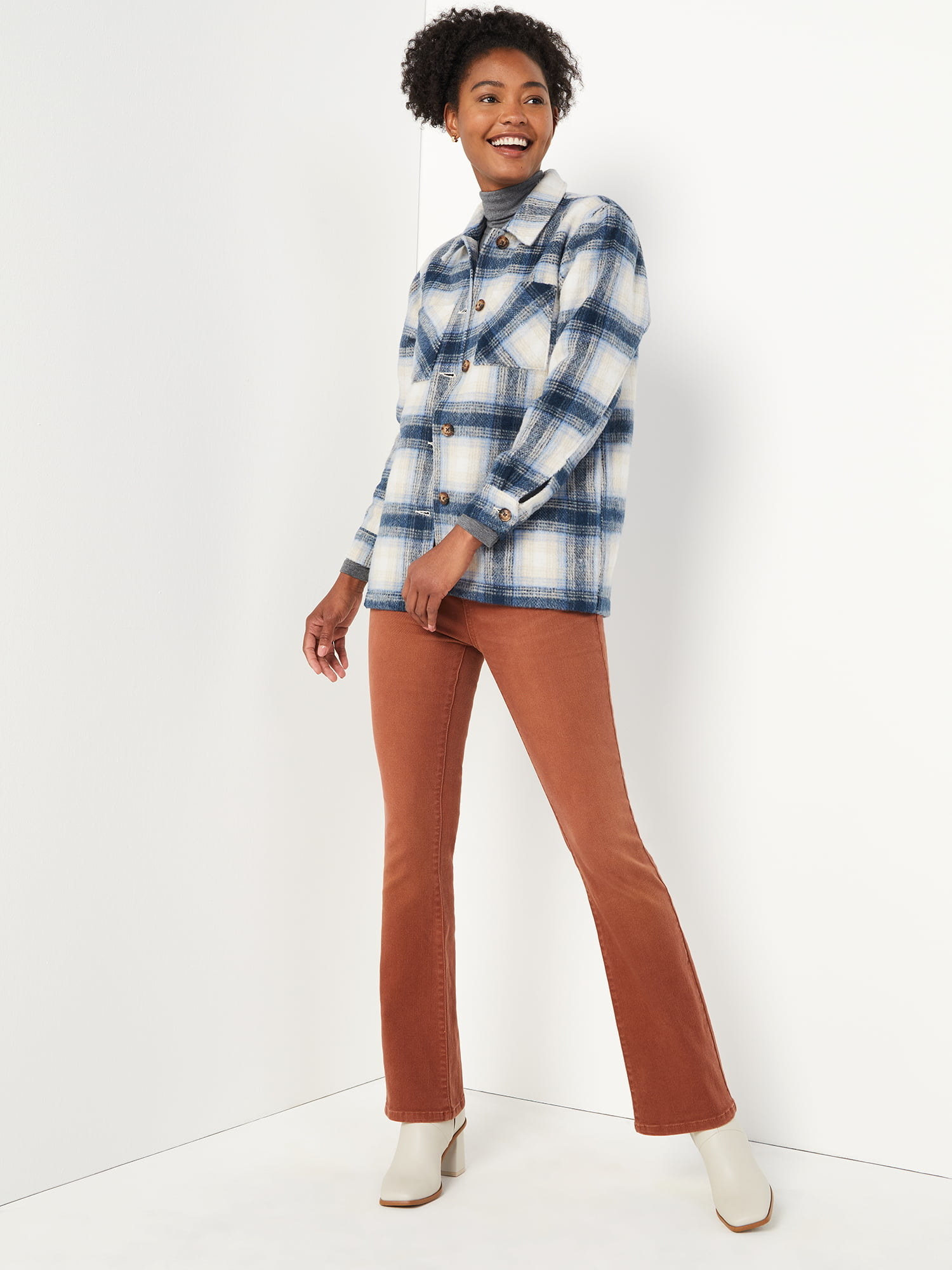 Model wearing the burnt orange pants with a flannel top and white boots