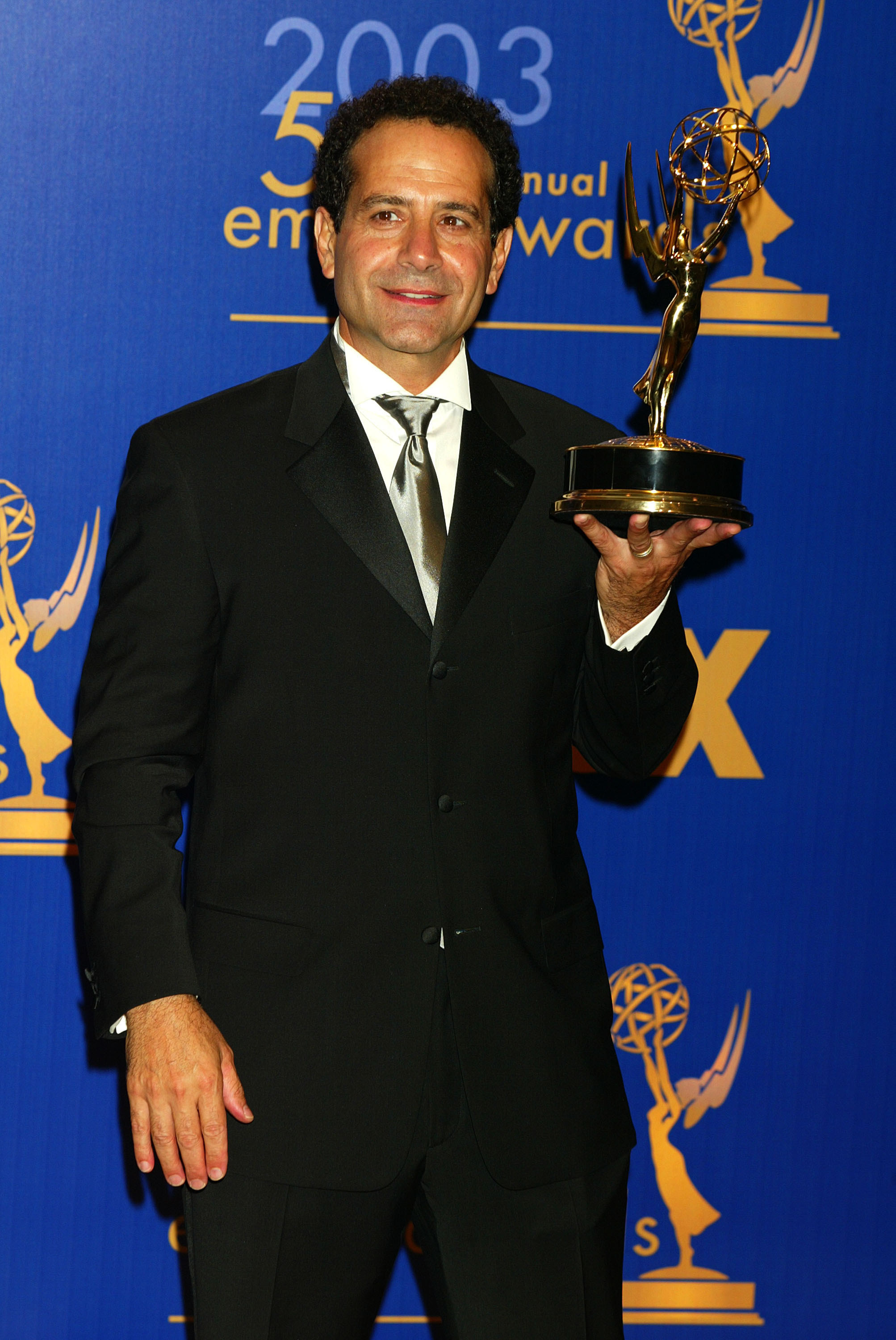 Tony Shalhoub holding an Emmy award