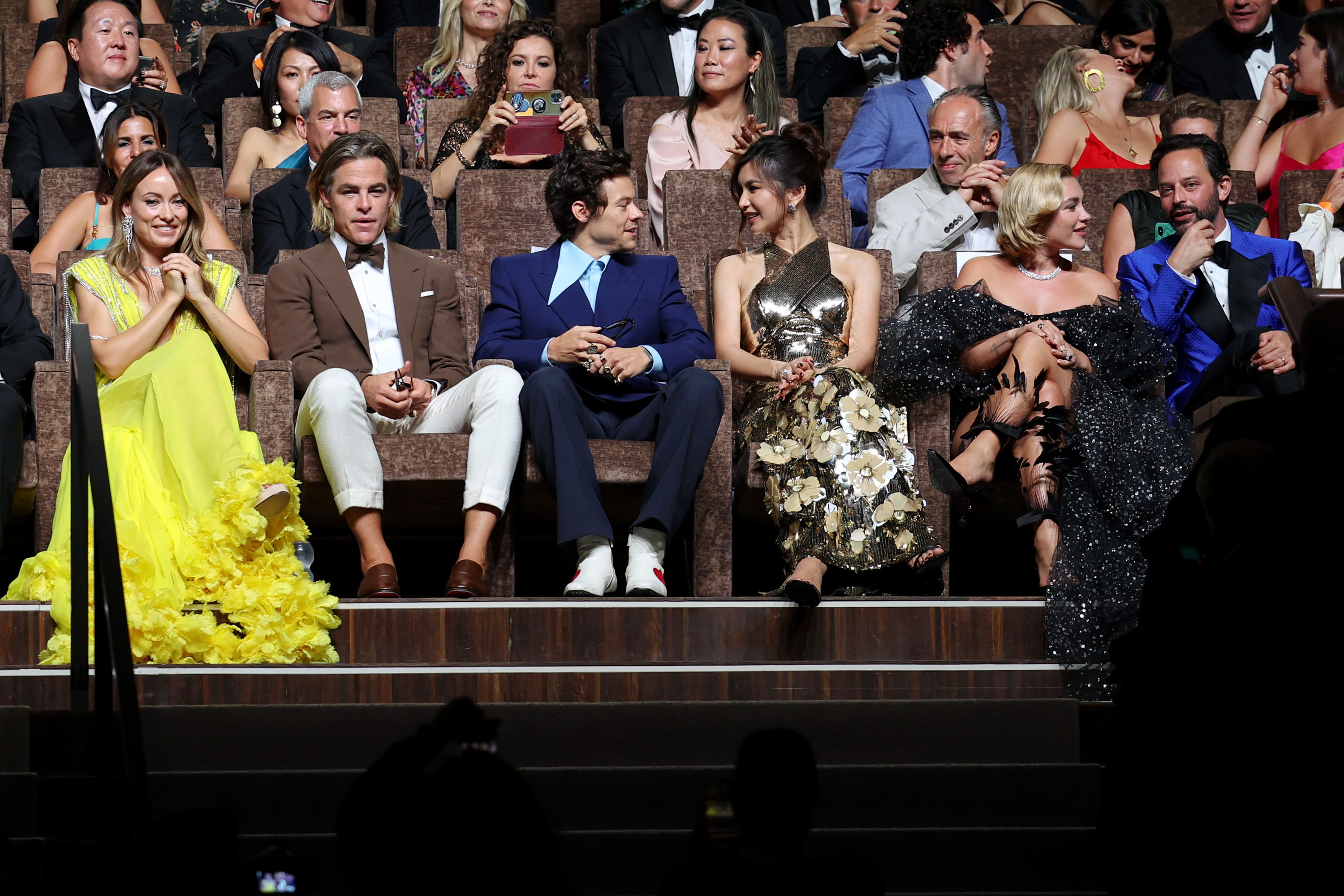 The cast sit in the theater