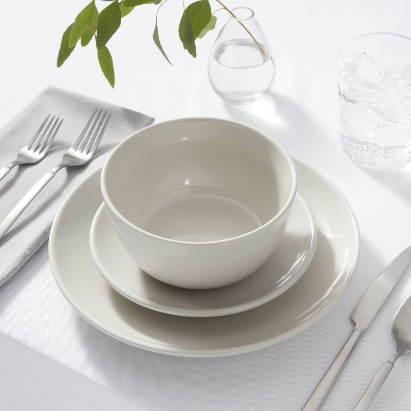 the light gray dinnerware in a place setting on a table