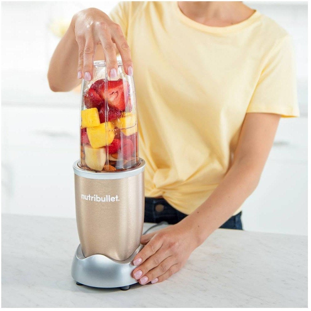 a model using the nutribullet to make a fruit smoothie