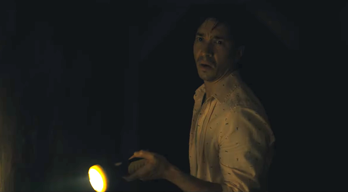 AJ holding a flashlight in a dark tunnel