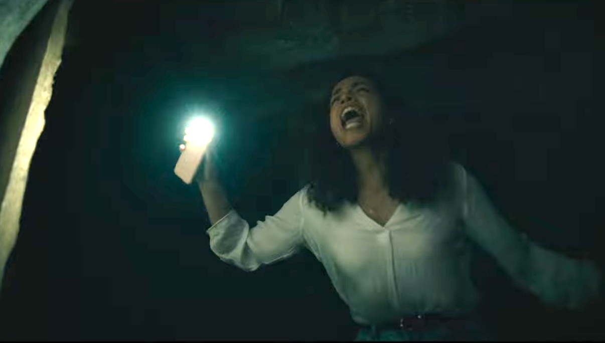 Tess using her phone as a flashlight, screaming