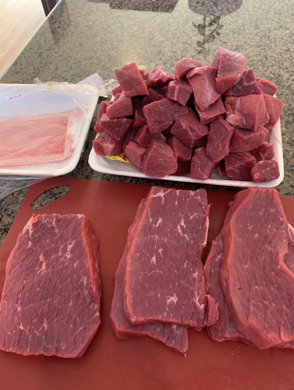 Several pieces of meat cut into cubes and strips of varying size