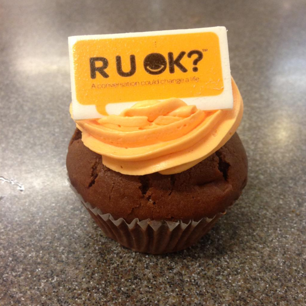 A cupcake with an R U OK day decoration