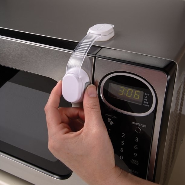 A hand pulling the safety strap attached to a microwave