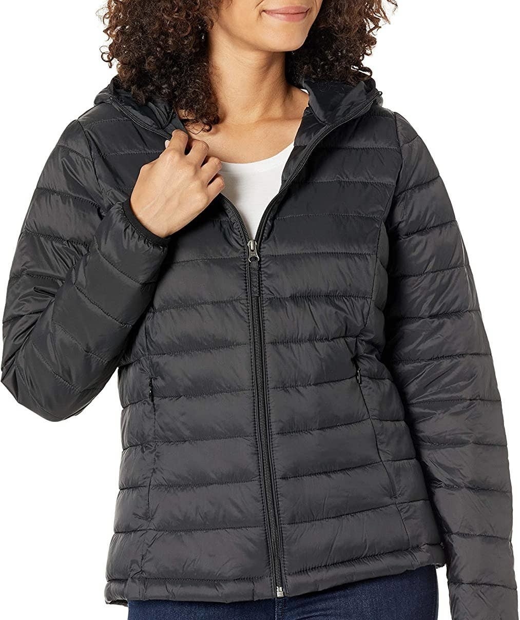 a person wearing the packable puffer jacker with jeans on a white background