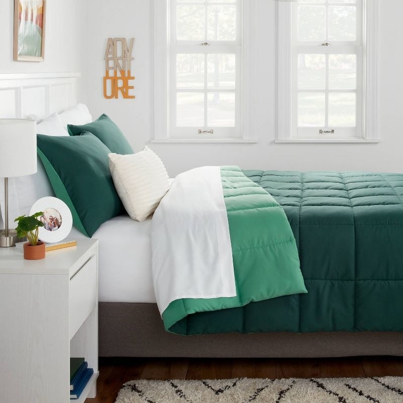 the green reversible comforter on a bed