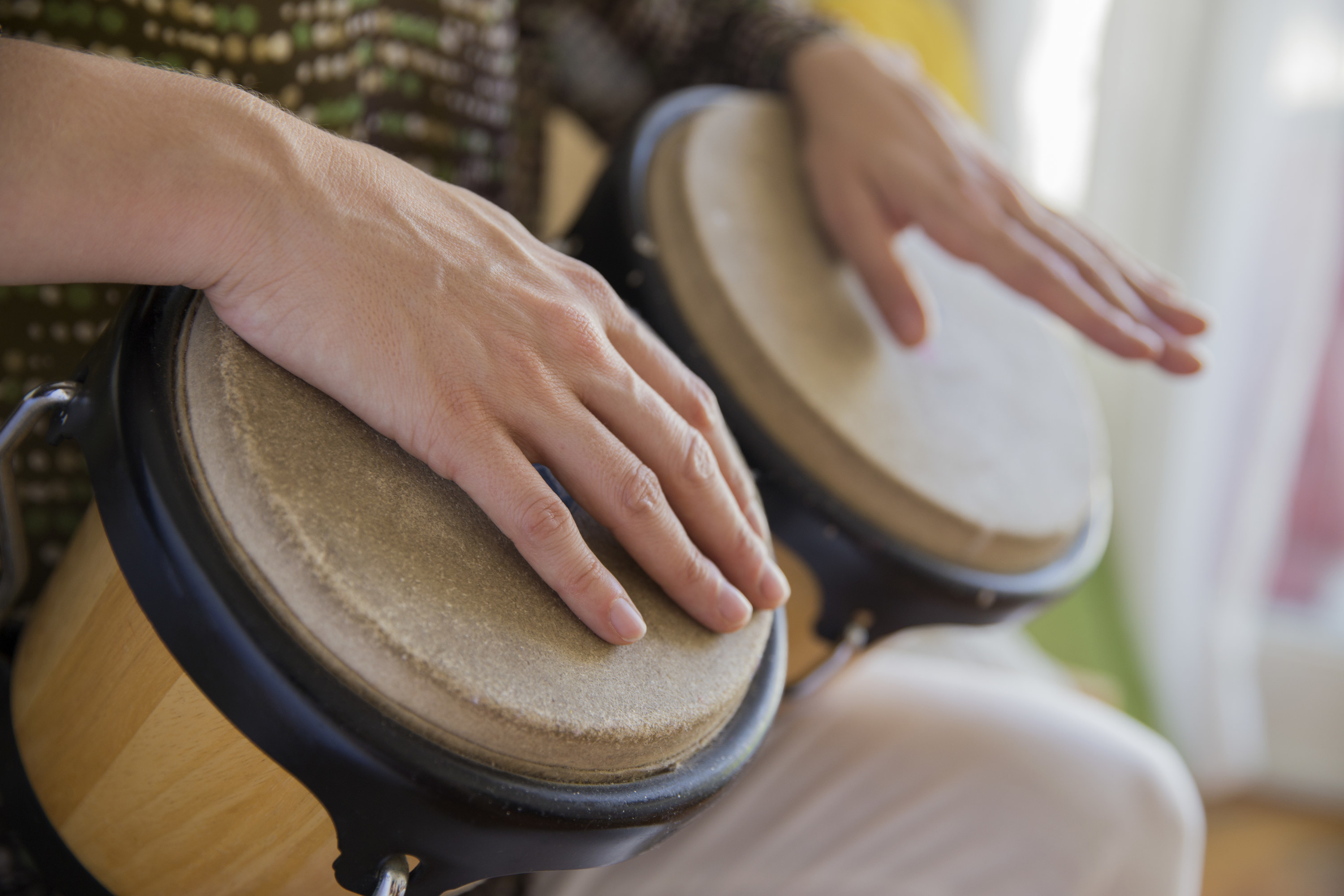 people&#x27;s hands on a set of bongo drums