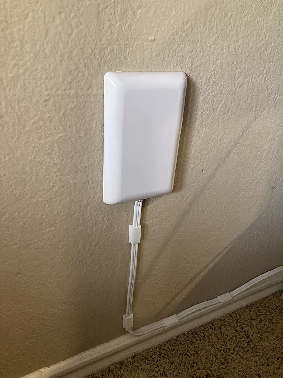 after: the socket, now with the powerstrip, plugged into the wall with the cord running along out of sight thanks to cord clips