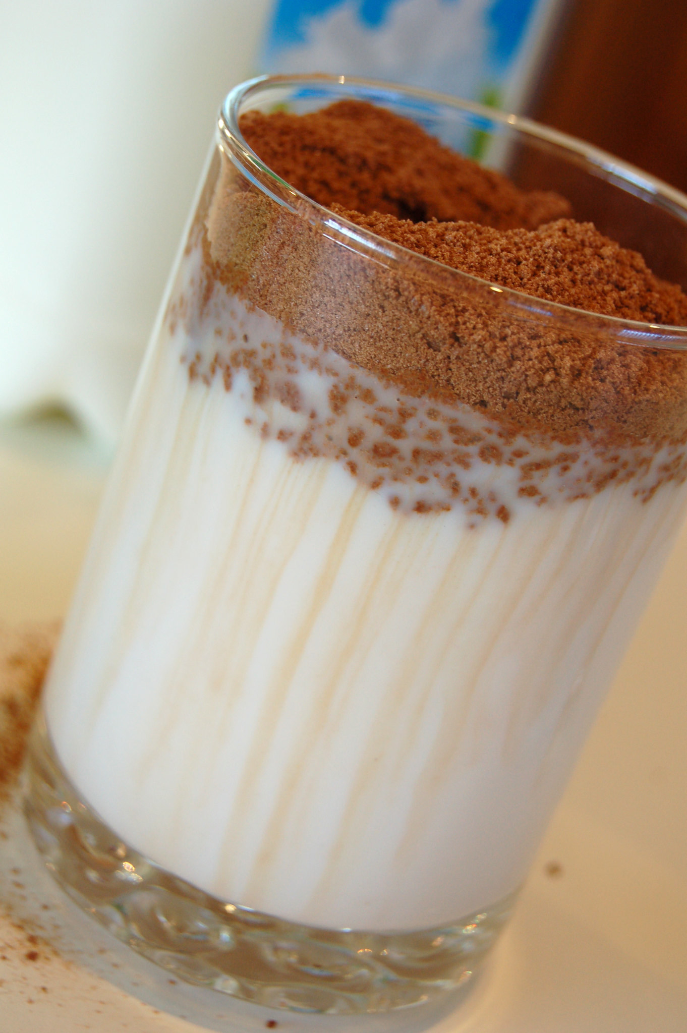 A glass of milk with a huge heaping of powdered Milo on top