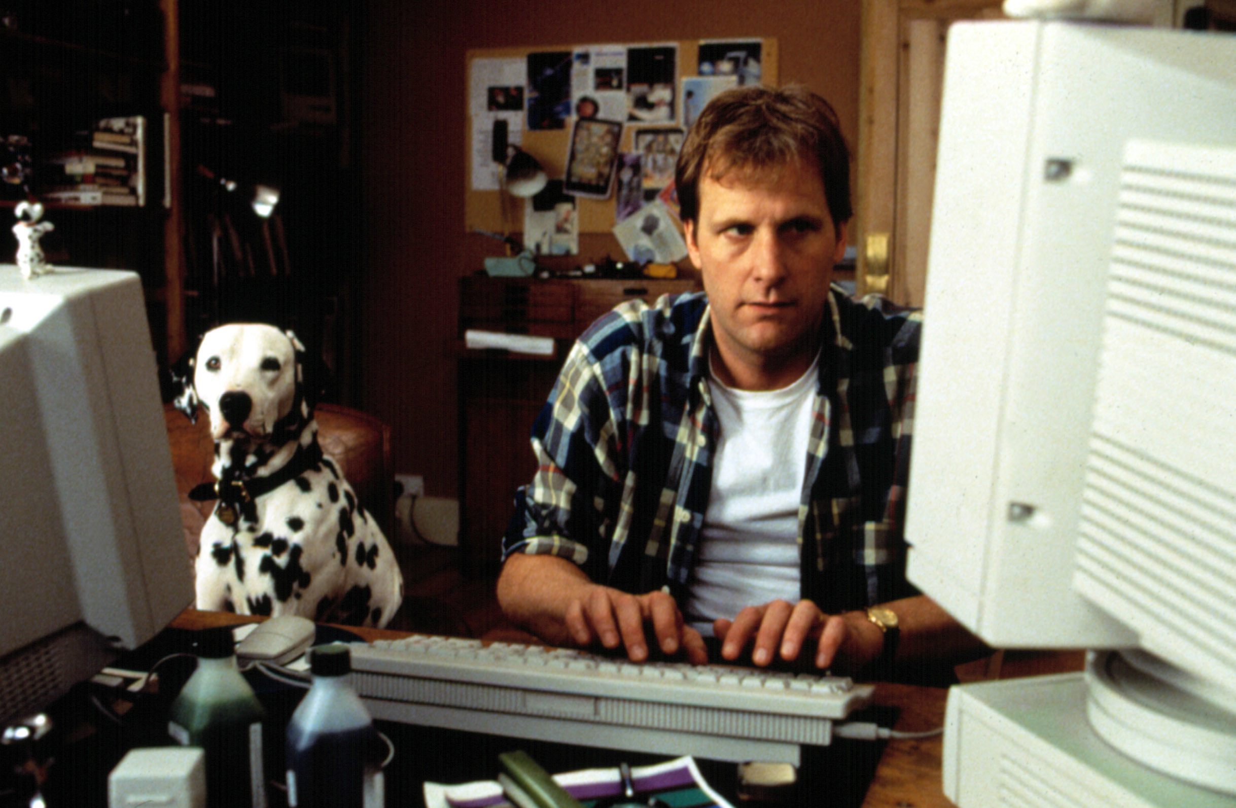 Jeff Daniels on the computer next to a dalmatian