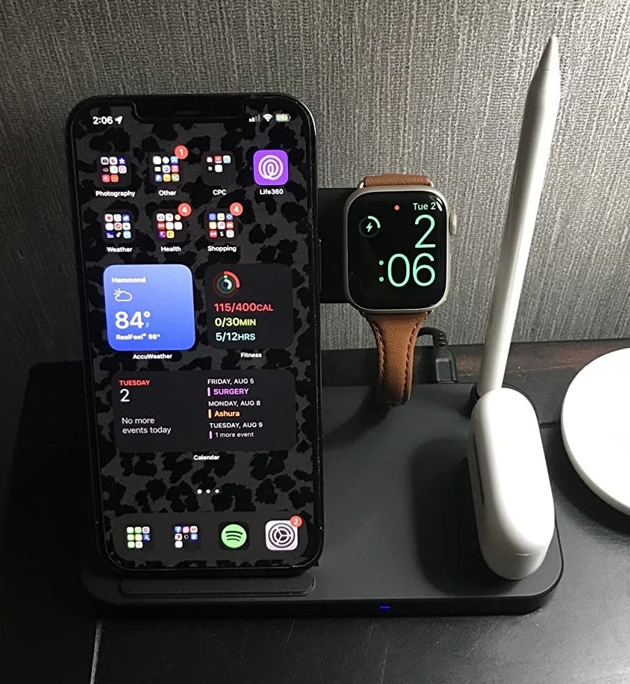 A charging station with a reviewer&#x27;s iPhone, Apple watch, AirPods, and Apple pencil all charging at the same time