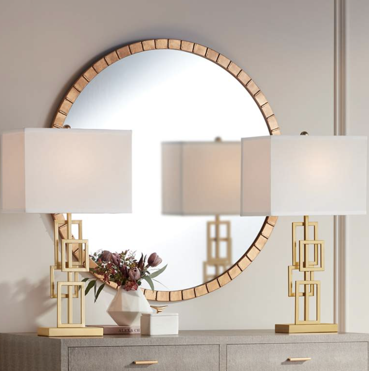 set of gale golden grid table lamps sitting on a dresser in front of a circular wall mirror