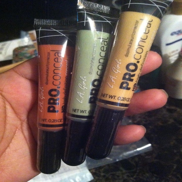 reviewer's hand holding correctors in the three shades available