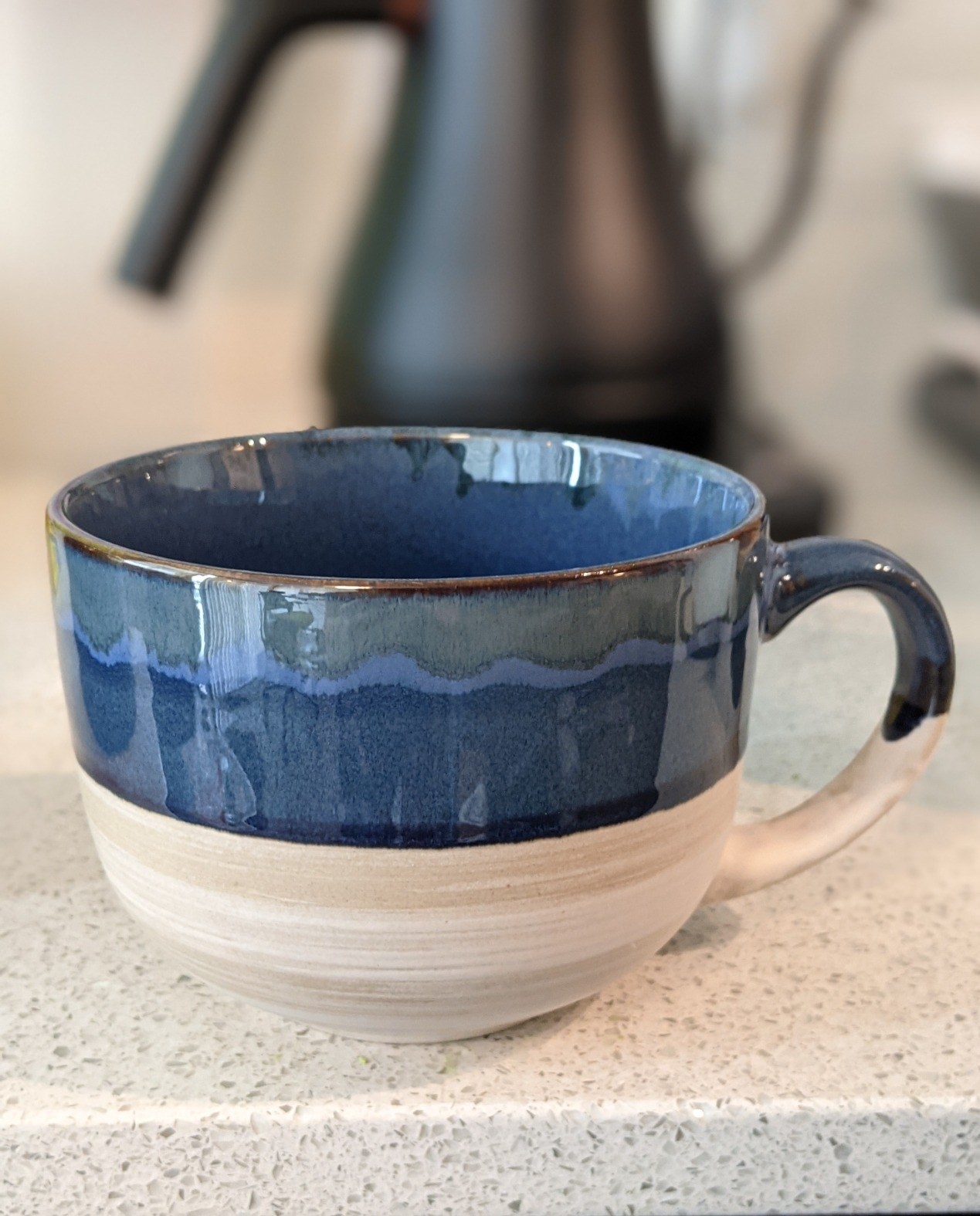 a reviewer photo of the blue and tan mug on a counter