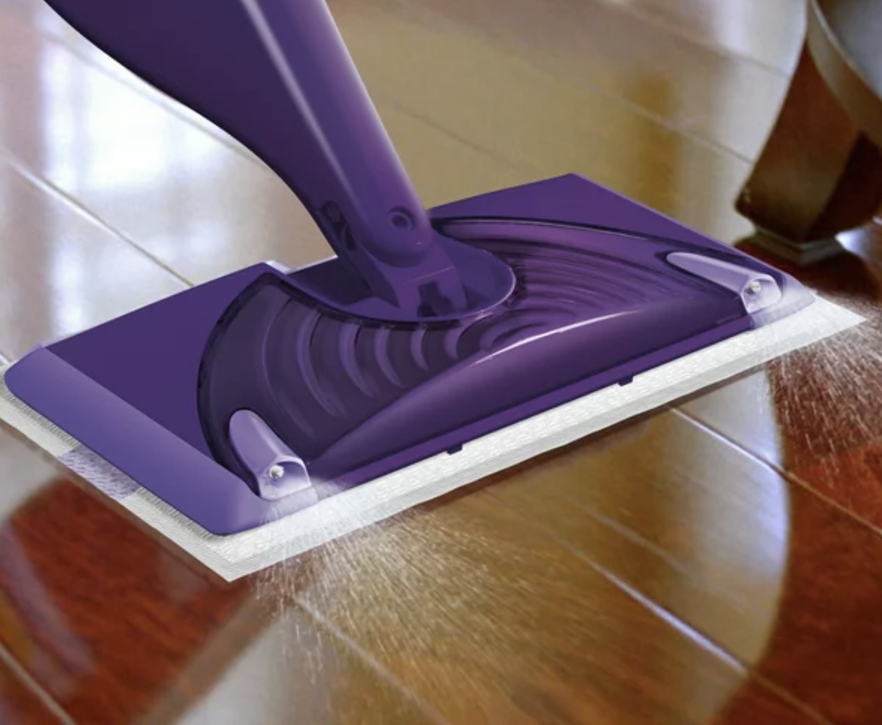 The purple mop sprays out cleaner on the wooden floor