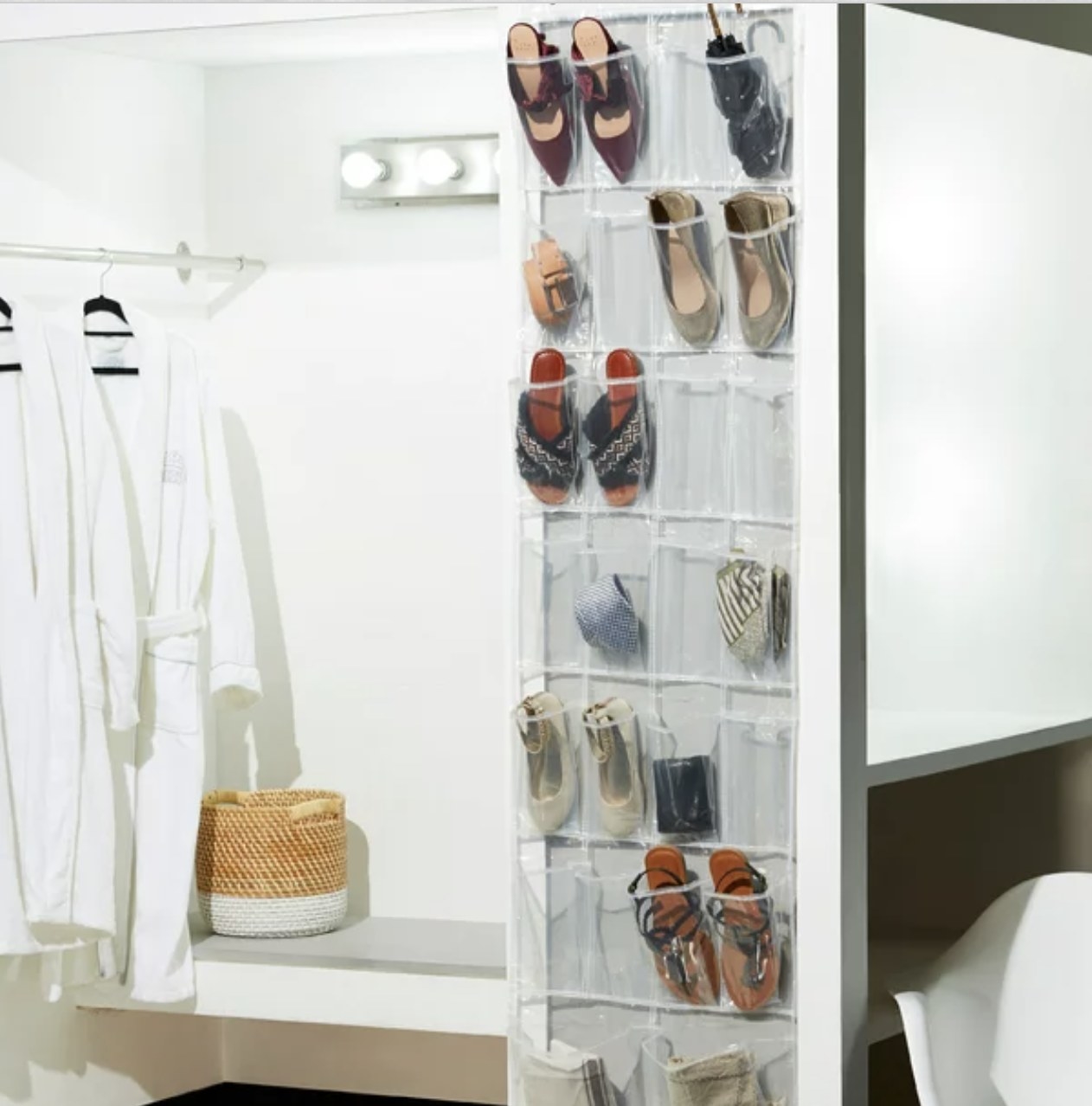The white shoe organizer is hung over door in a well lit room
