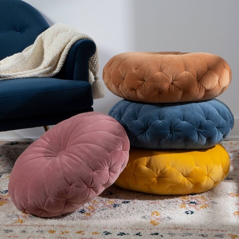 the four round floor pillows in different colors