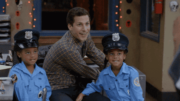 Jake from &quot;Brooklyn Nine-Nine&quot; smiles as Detective Holt jumps out, holding a crown and winking