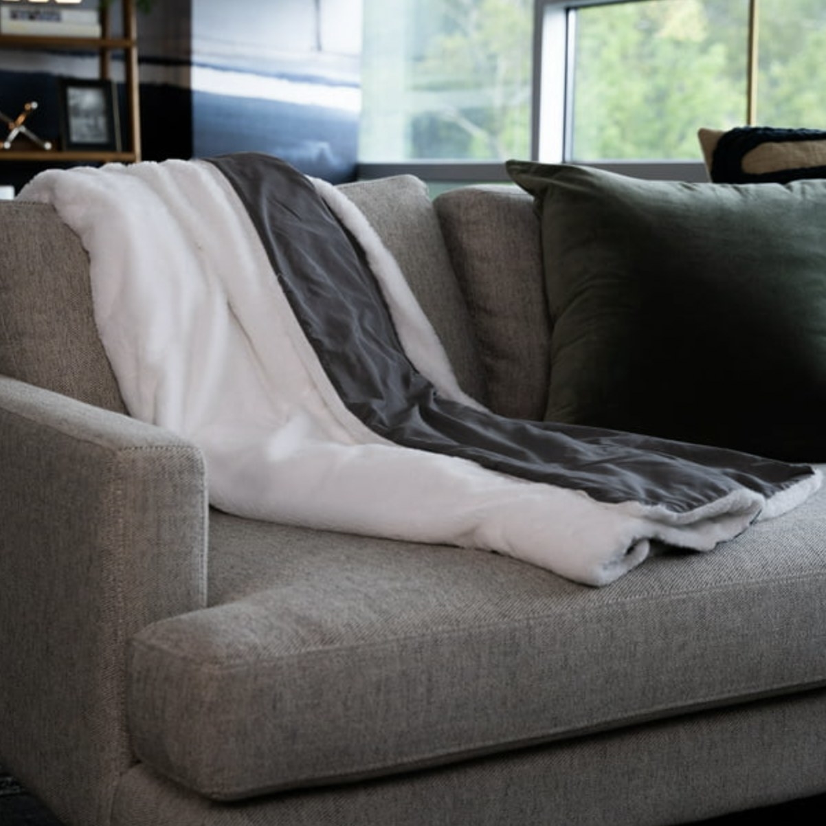The grey/white blanket draped on couch