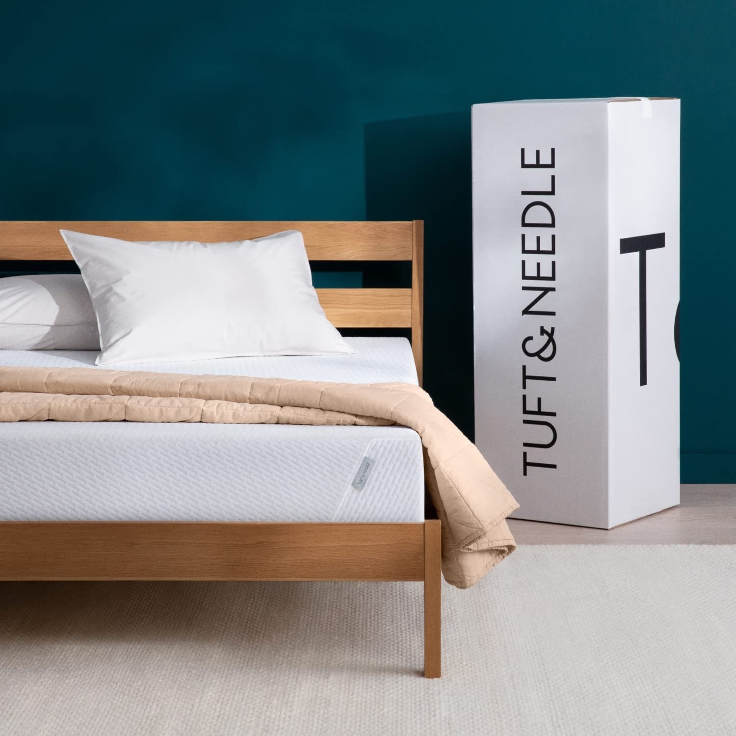 tuft and needle white mattress on a bed next to box