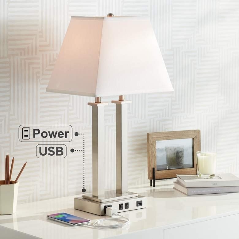 USB-friendly lamp with gray base and white shade placed on top of table