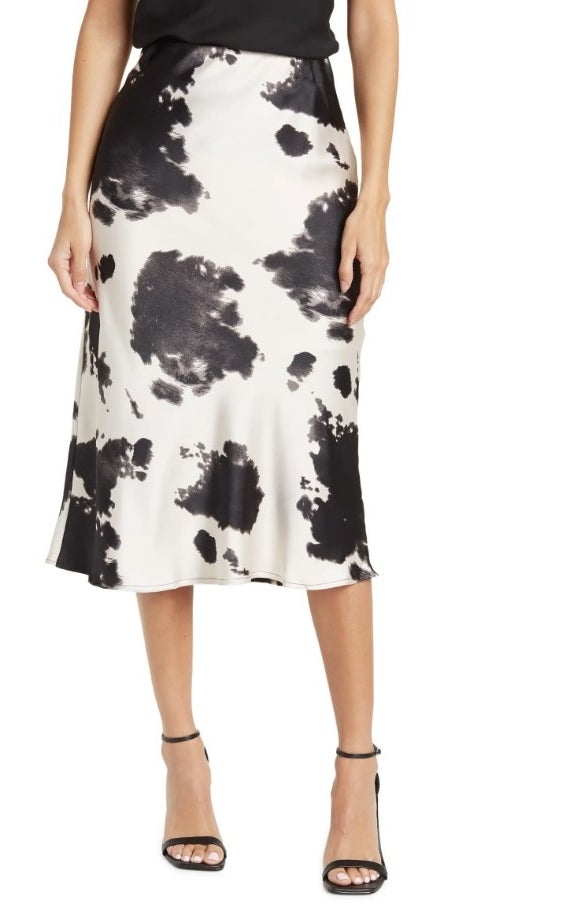 A model wearing a black/white cow satin midi skirt