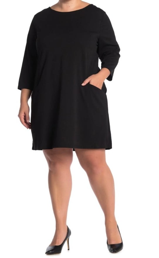 A model wearing a black 3/4 sleeve dress