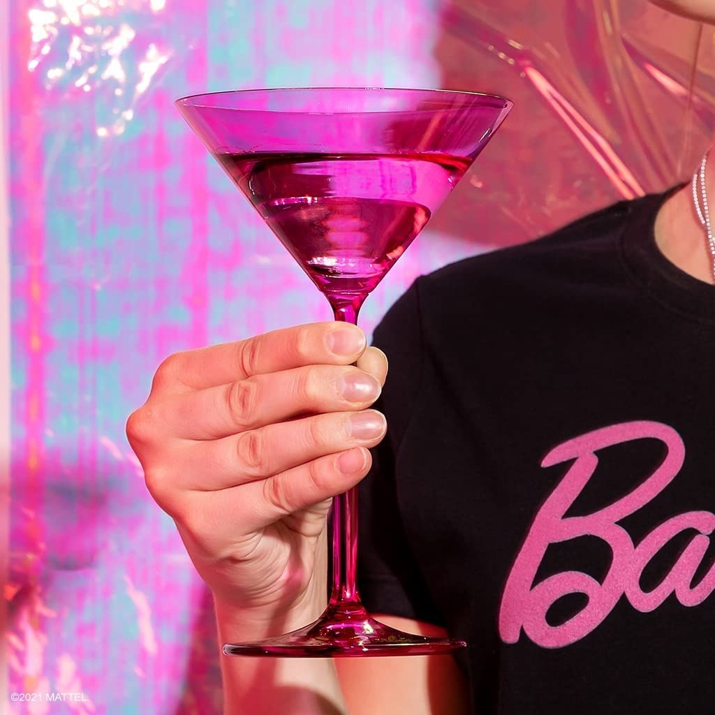 hand holding hot pink martini glass