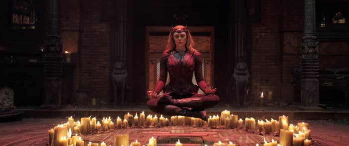 The Scarlet Witch sitting cross-legged and levitating above a circle of candles
