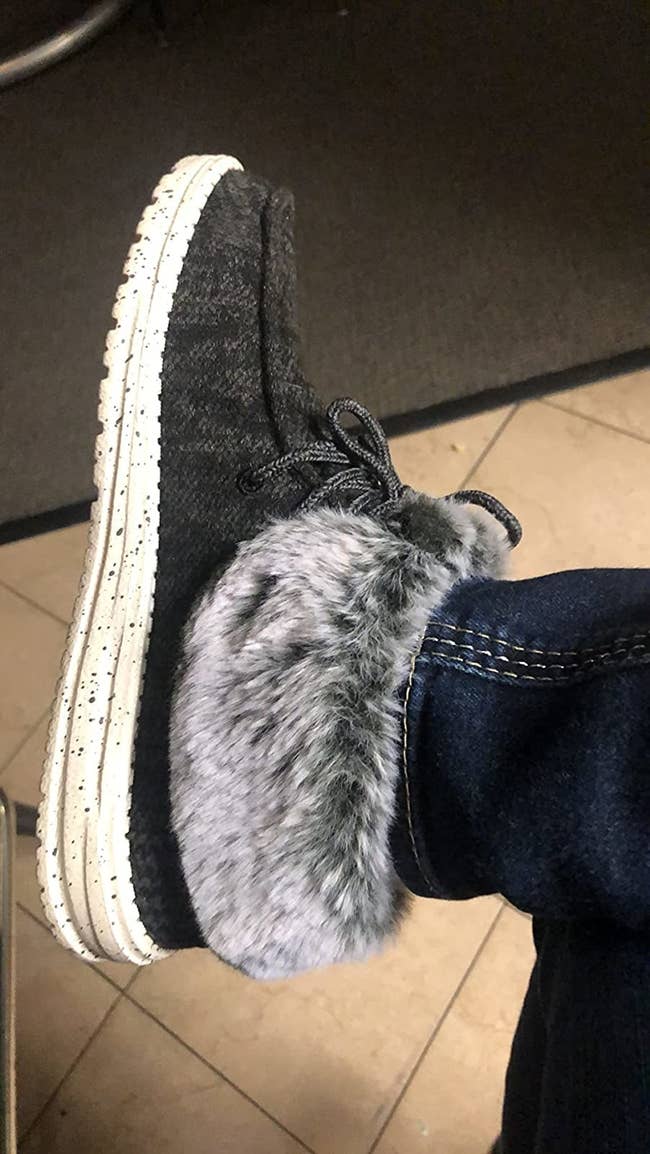 A reviewer wearing the shoes with a fuzzy foldable cuff