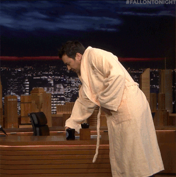 gif of jimmy fallon on the tonight show in a robe and drinking coffee