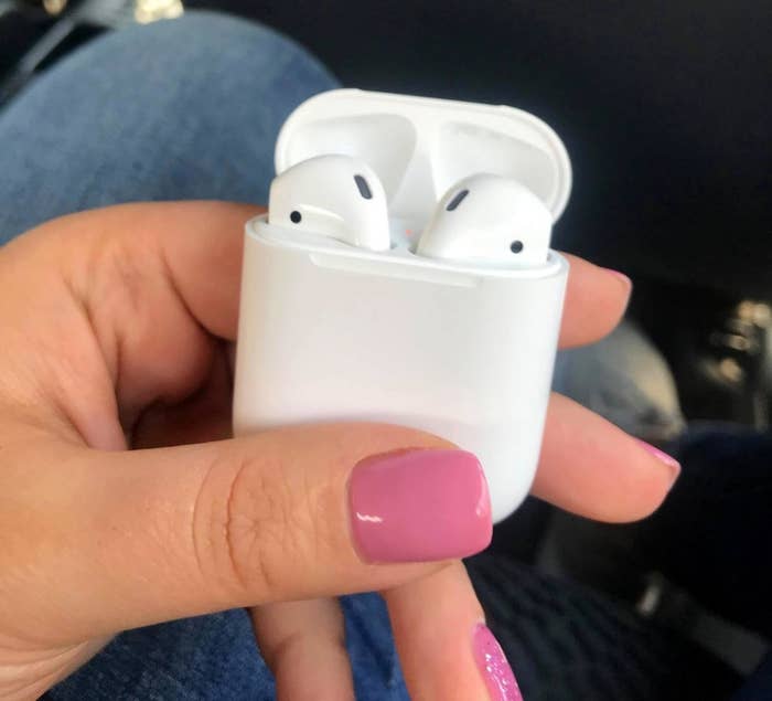Reviewer holding Apple AirPods