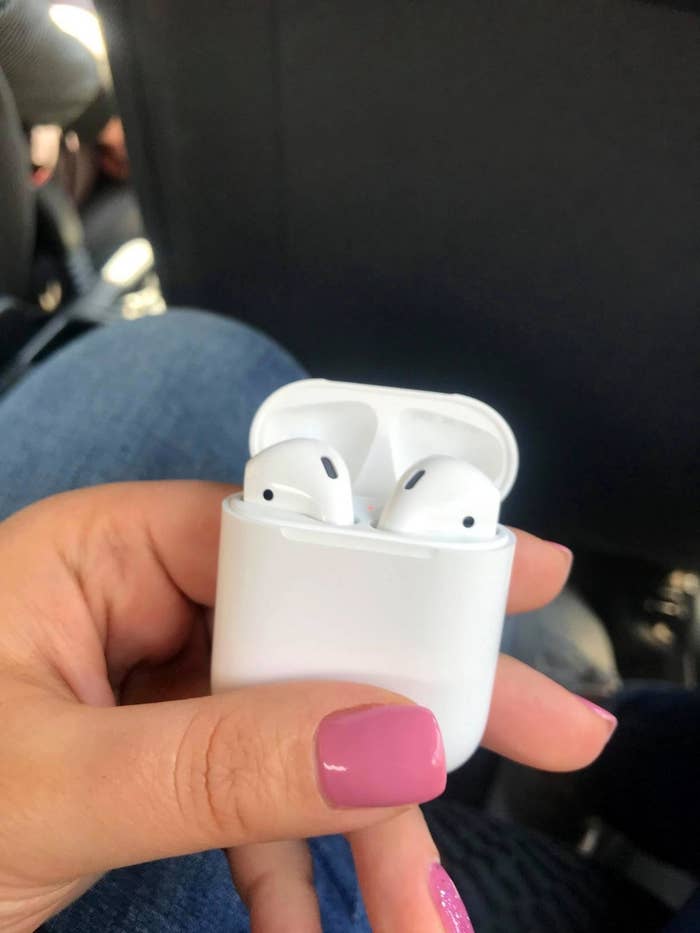 Reviewer holding Apple AirPods