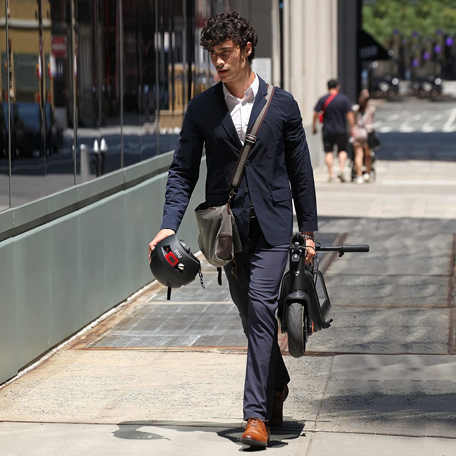 a person carrying the folded up electric scooter to their office