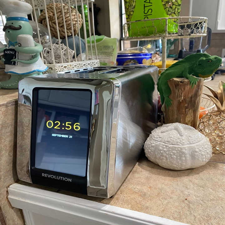 The toaster not in use showing the time on its screen