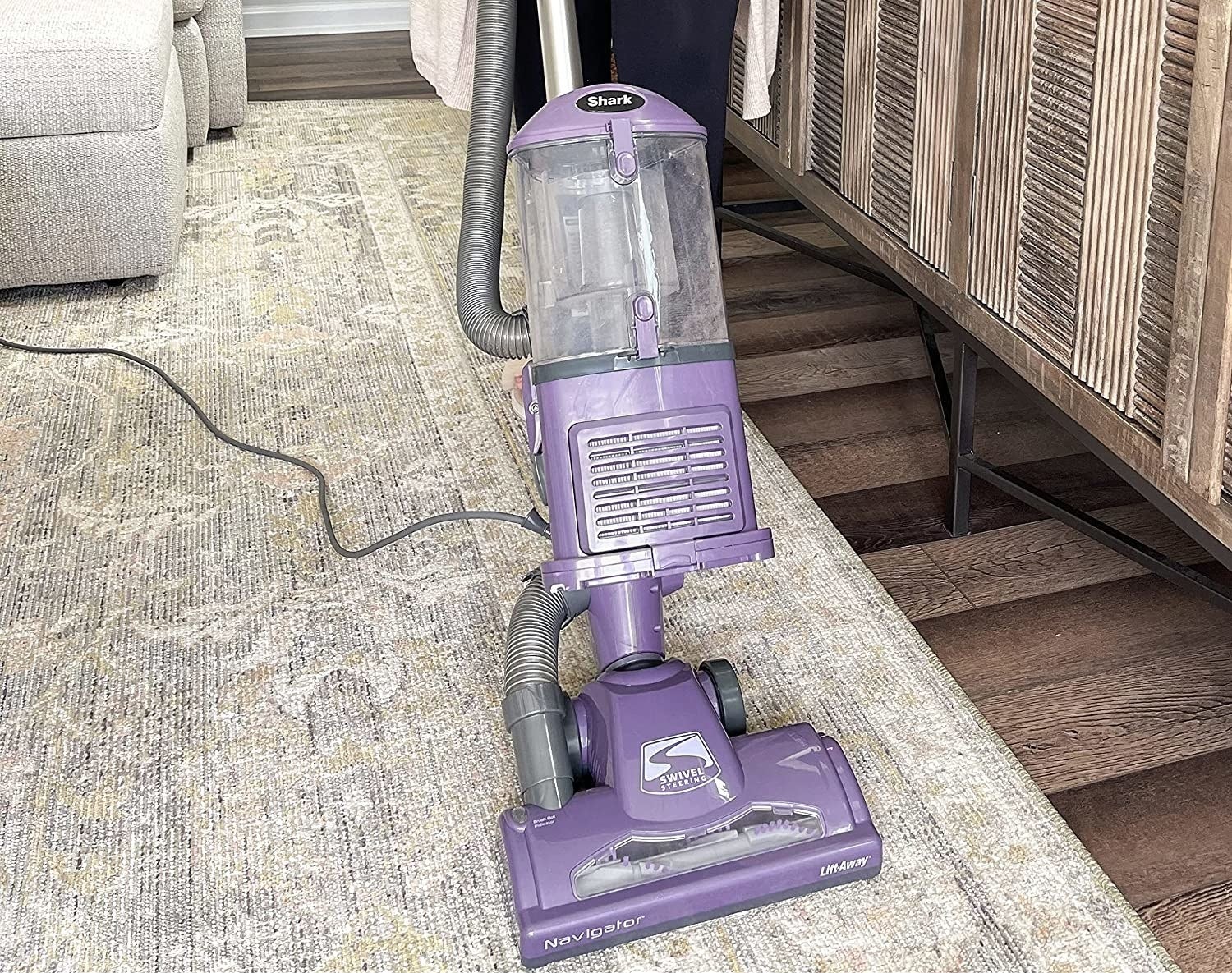the purple corded vacuum cleaning a rug