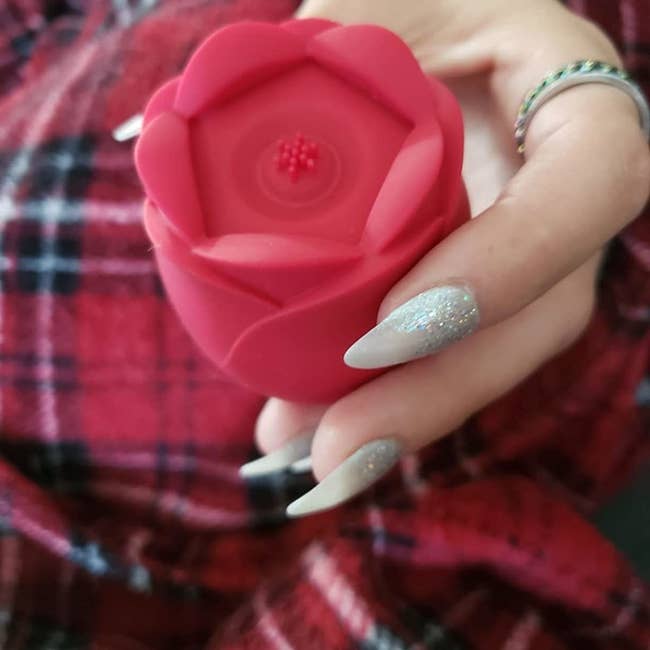 Reviewer holding red rose vibrator