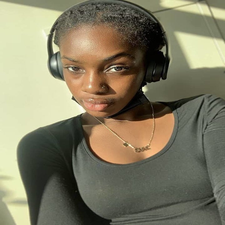 A reviewer wearing the black headphones