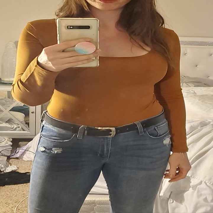 reviewer wearing the gold bodysuit with jeans
